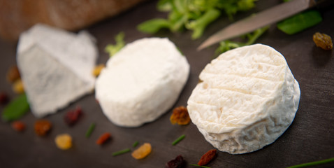 French goats cheeses and bread on background