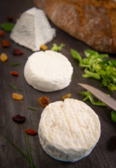 French goats cheeses and bread on background