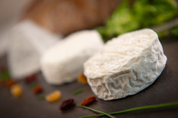French goats cheeses and bread on background