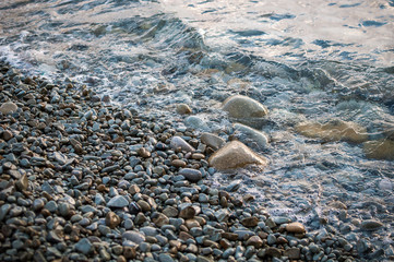 Obraz premium Large stones on the beach, washed by the wave