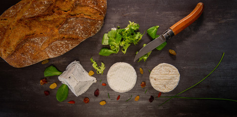 French goats cheeses and bread on background