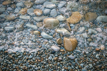 Large stones on the beach, washed by the wave