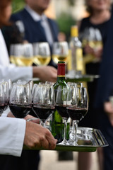 Professional waiter in uniform is serving wine
