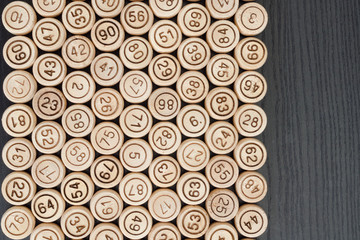 Wooden kegs of lotto on the edge of the black table. Space for text