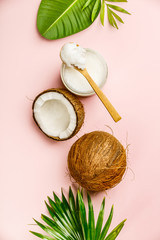 Coconut oil, tropical leaves and fresh coconuts