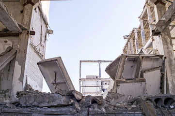 The remains of the destroyed building of a large industrial facility. Background