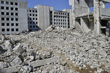 The remains of the destroyed building of a large industrial facility. Background