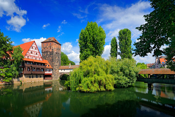 Summer view of the German traditional medieval half-timbered Old Town architecture and bridge over Pegnitz river in Nuremberg, Germany. City with blue sky.