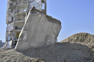Concrete slab walls of the building separately sticking out of the ground. Background