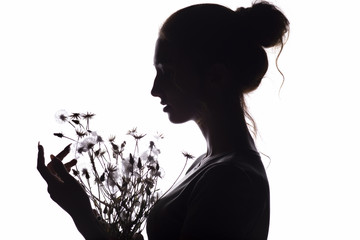 silhouette of girl with a bouquet of with dandelions, young woman face on a white isolated background