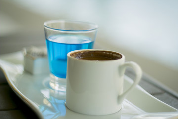 Traditional Oriental nougat with Turkish coffee and blue water on a tray