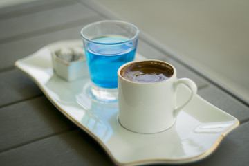 Traditional Oriental nougat with Turkish coffee and blue water on a tray