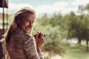 Smiling woman having coffee in morning