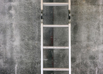 Step ladder near gray wall.