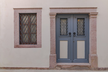 Fototapeta na wymiar Wooden door and stone wall of historical house in Ayvalik