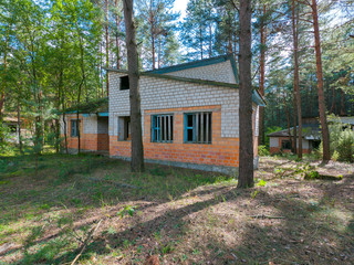 Fototapeta na wymiar thrown brick houses with wooden windows in a coniferous forest
