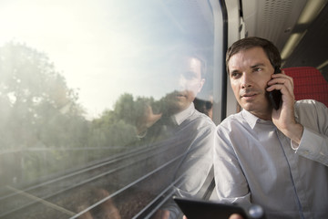 Businessman on the phone whilst travelling by train