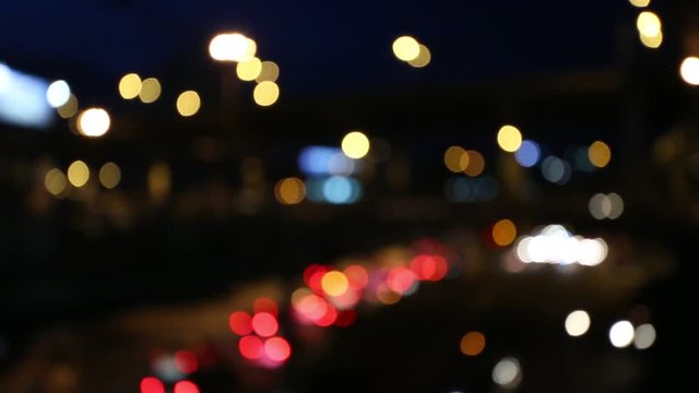 Abstract circular bokeh motion lens blur backround of city and street light on rainy day at night time in Thaialnd. Particles boken of light background with traffic in the city.