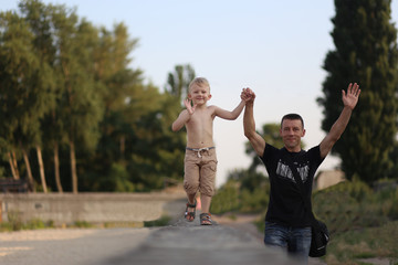Fototapeta premium happy family father son walking arms raised smiling