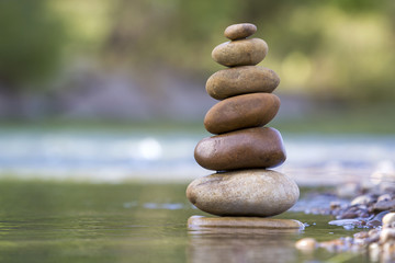 Close-up abstract image of wet rough natural brown uneven different sizes and forms stones balanced...