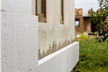 Close-up detail of plastered house wall with rigid styrofoam insulation. Modern technology,...