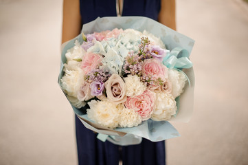 Girl holding a beautiful bouquet of pastel color flowers
