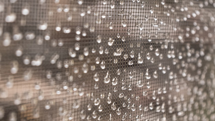 Raindrops water drops on the window grid in brown tones