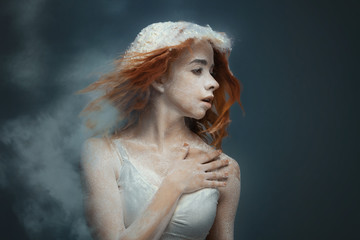 Dancing in flour concept. Cute fitness beauty redhead woman / female / adult dancer performer in dust / fog. Portrait of a girl dancer with ginger hair in flour on isolated backround