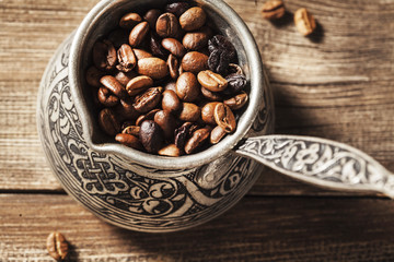 Coffee pot and coffee beans on wooden background