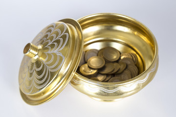 isolated old gold color copper kitchenware and coins on the wooden background.