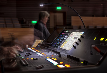 music, technology, people and equipment concept - hands using mixing console in sound recording...