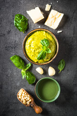 Pesto sauce with ingredients on dark stone table. 