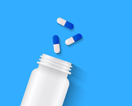 White and blue capsules with white pill bottle on blue background