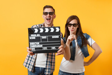 Young fun couple woman man in 3d glasses watching movie film on date holding classic black film...