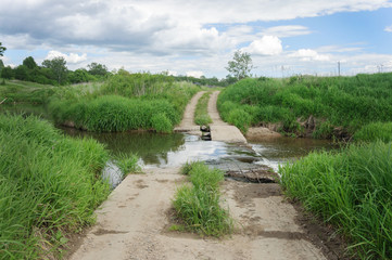 Country road with pond on a brook