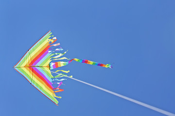 multi-colored kite flying on a blue sky background