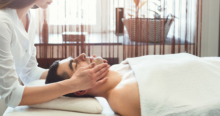 Obraz na płótnie Canvas Man having head massage in salon