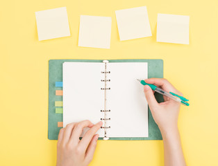 girl's hand writing in notepad