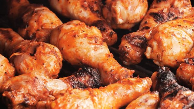 UHD shot of the marinated chicken drumsticks on the grill