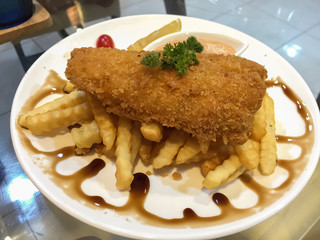 Fried fish steak with chips and black sauce