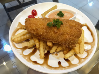 Fried fish steak with chips and black sauce