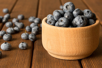 Fresh blueberries on a wooden table in a wooden plate. Close up. The concept of natural food