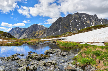Siberian mountain landscape. Stones covered with mosses and lichens over water