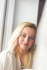 Naklejka premium Beauty Woman face Portrait. Blond female looking at camera and smiling touching face.