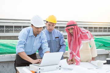 Muslim businessman, engineer, architect and worker team discussing about building plan for construction at job site. Teamwork collaboration relation concept