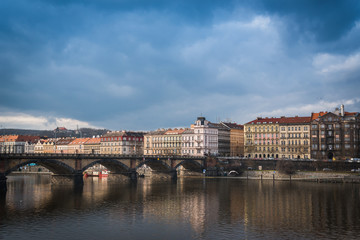 Palacky bridge over Vltava river in Prague, Czech Republic. Buildings and cloudy sky in the background. Space in the top side