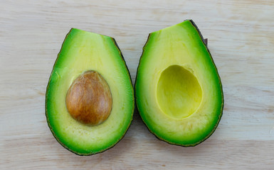 half of fresh avocado on wood block