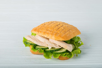 Pressed and toasted double panini with ham and cheese served on sandwich paper on a wooden table