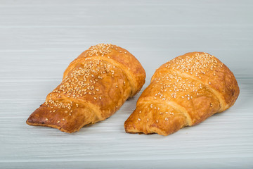 two croissant sprinkled with powdered sugar isolated on a white background closeup