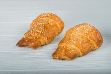 two croissant sprinkled with powdered sugar isolated on a white background closeup